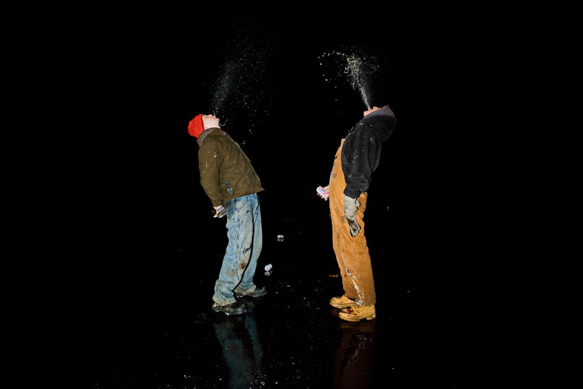 Two young men spit beer into the dark, cold night sky by Giacomo Fortunato.