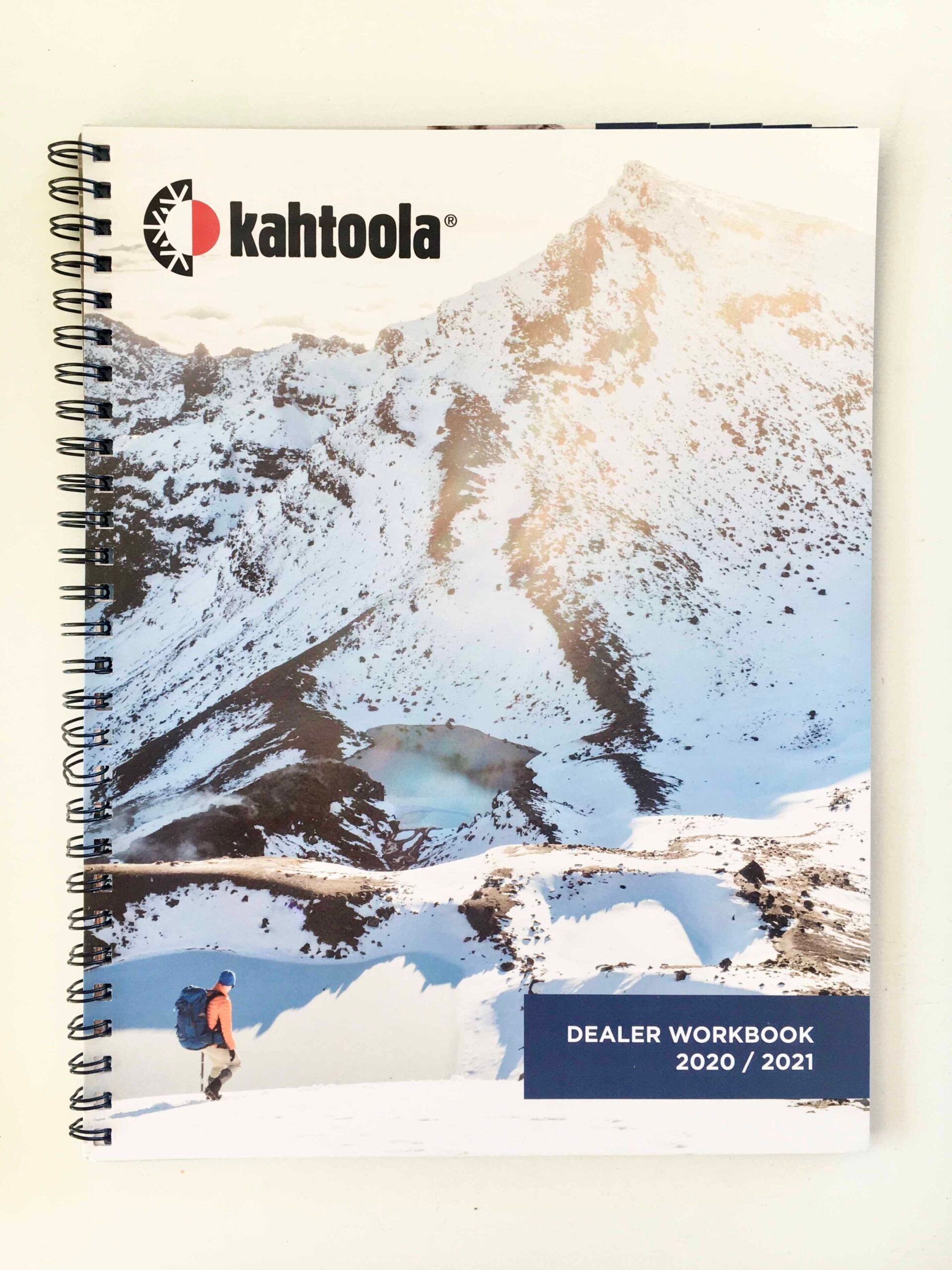 Cover shot of Kahtoola shot of the workbook showing a hiker at the foot of a snow-covered mountain during sunrise.