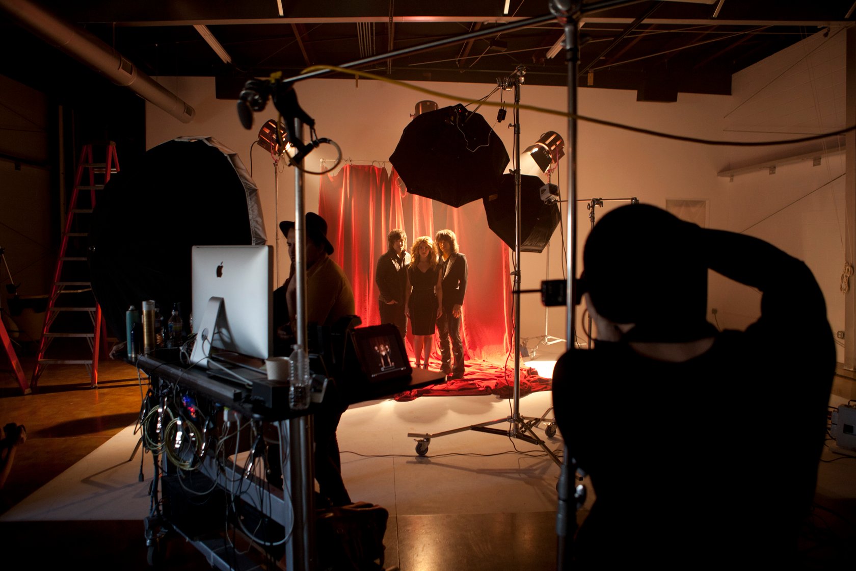 A behind the scenes image of The Band Perry against a red backdrop photographed by Robby Klein.