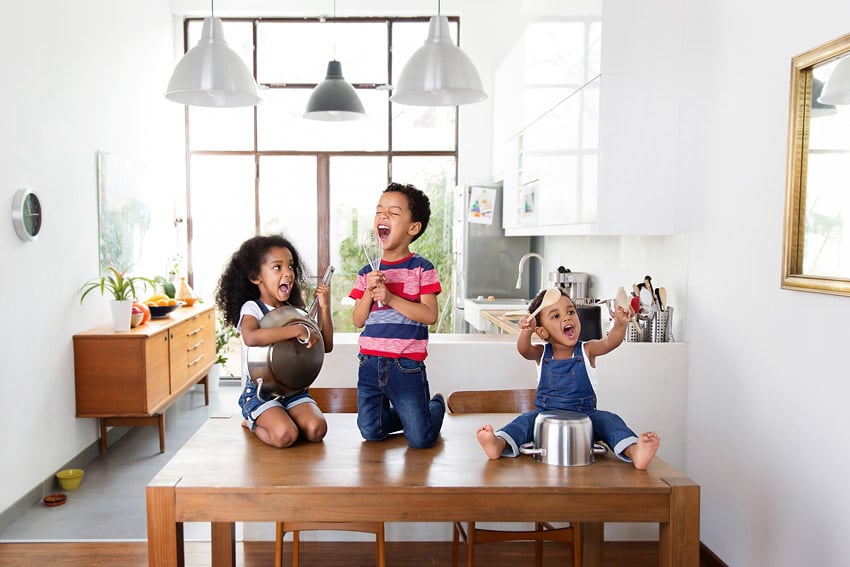 A photograph of children playing with kitchen utensils shot by Lisa Tichane.