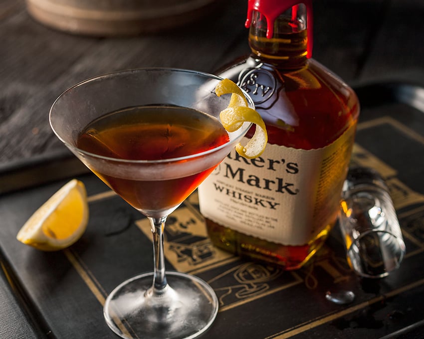 Terri Campbell's shot of a Manhattan with a twist of lemon sitting next to a bottle of Maker's Mark.