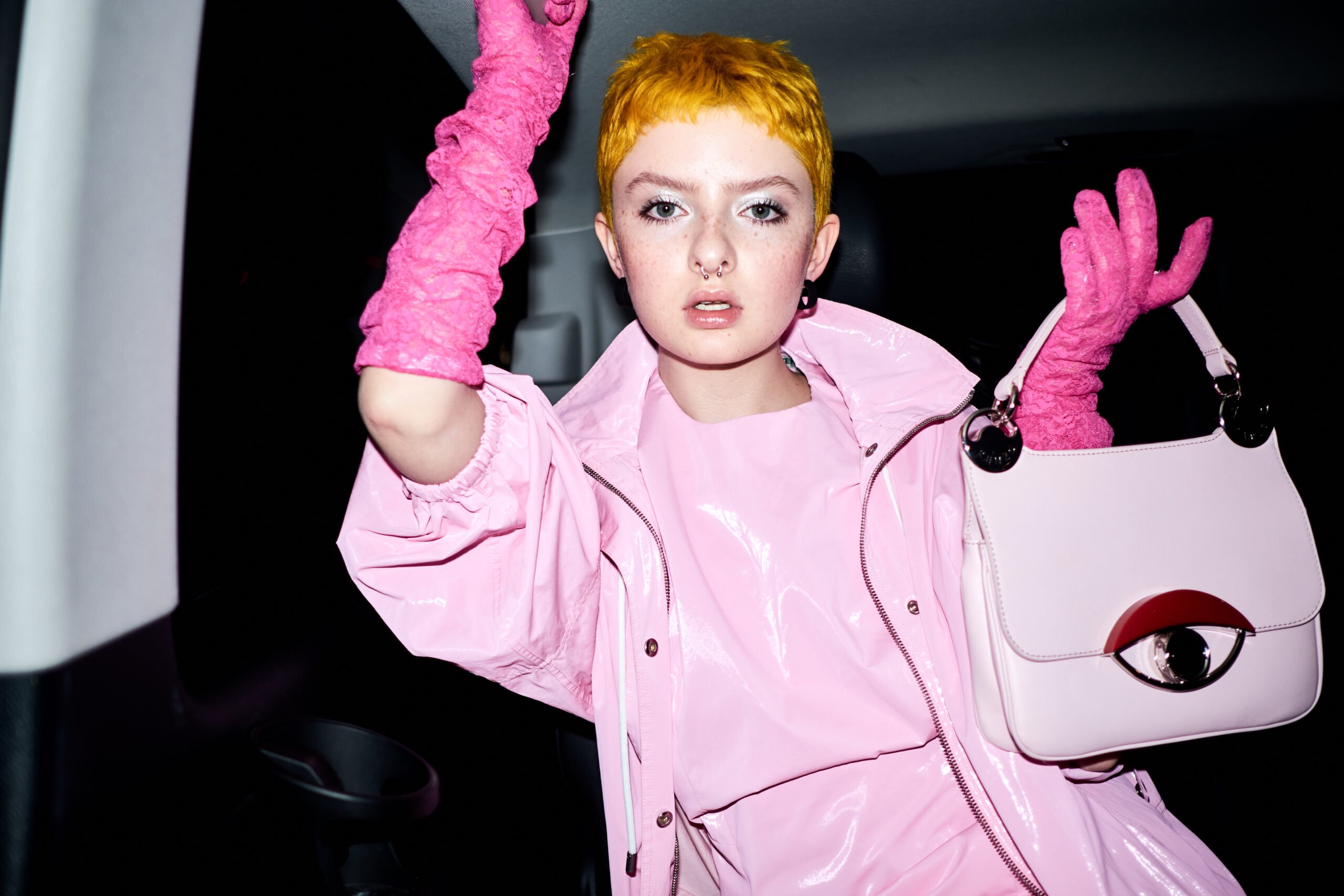 Jillian Clark's photo of Lachlan Watson is wearing a candy pink vinyl jacket and dress with hot pink gloves