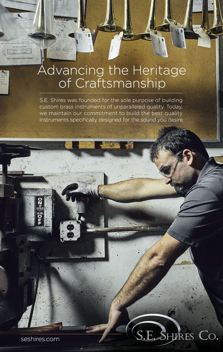 Doug Levy's tear sheet for S.E. Shires featuring a photo of a craftsman wearing protective goggles and a protective glove on one hand in a workshop. He guides a piece of material through a machine.