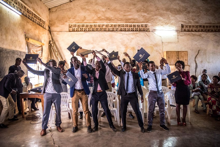 A class of students showing off their degrees, photo by Alex Buisse