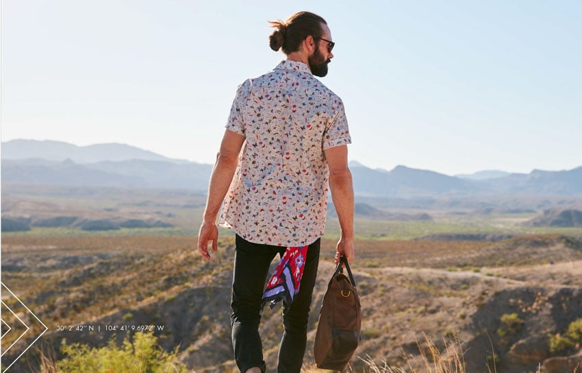 A man wearing a print shirt, posing in the desert in Ruidosa, photography by Andrew Klein.