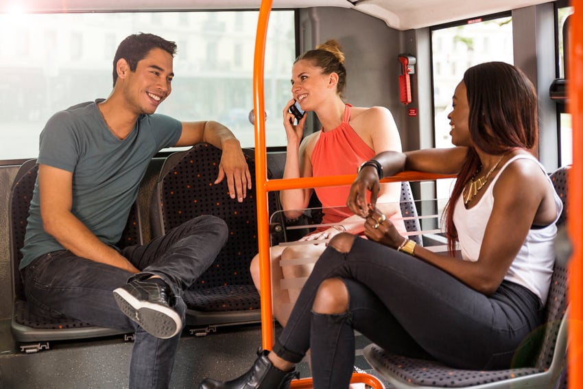 Aurélien Bergot's photograph for Geneva Public Transport featuring three people smiling at each other while sitting on a bus.