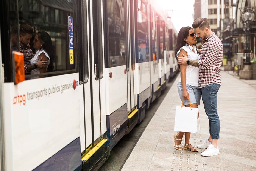 Aurélien Bergot's photograph for Geneva Public Transport featuring a man and woman in an intimate embrace on the sidewalk outside of a bus on the street.