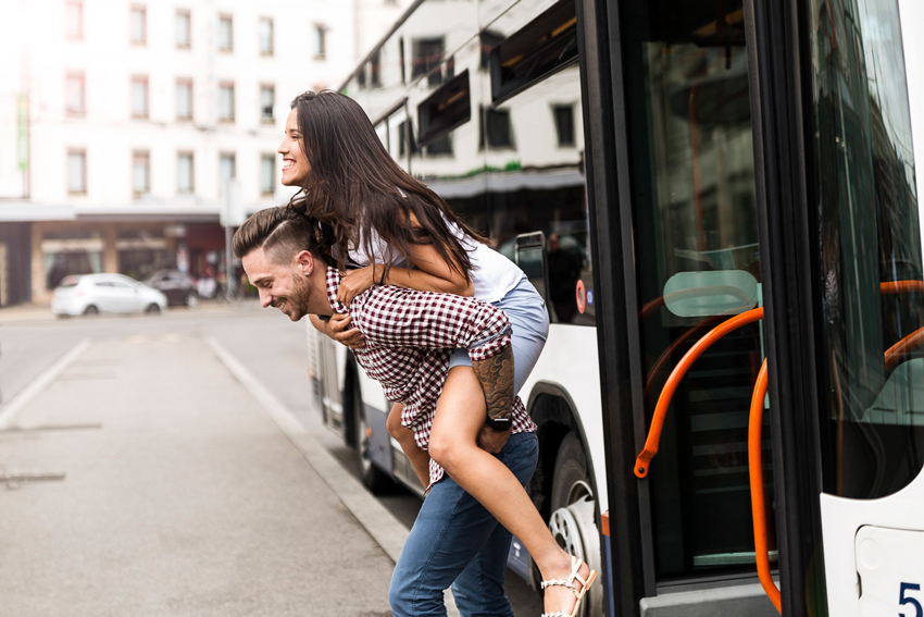 Aurélien Bergot's photograph for Geneva Public Transport featuring a man giving a woman a piggy-back ride from a bus on the street.