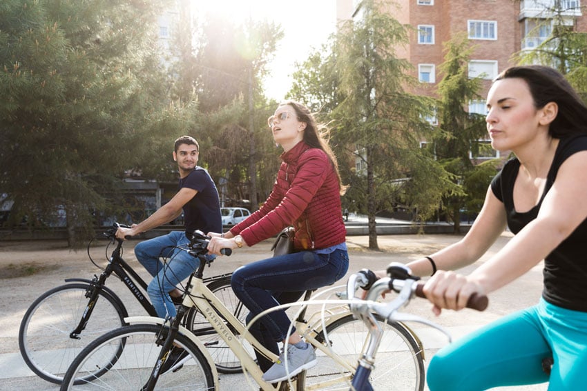 Three students cycling at NYU Madrid, shot by Clint McLean.
