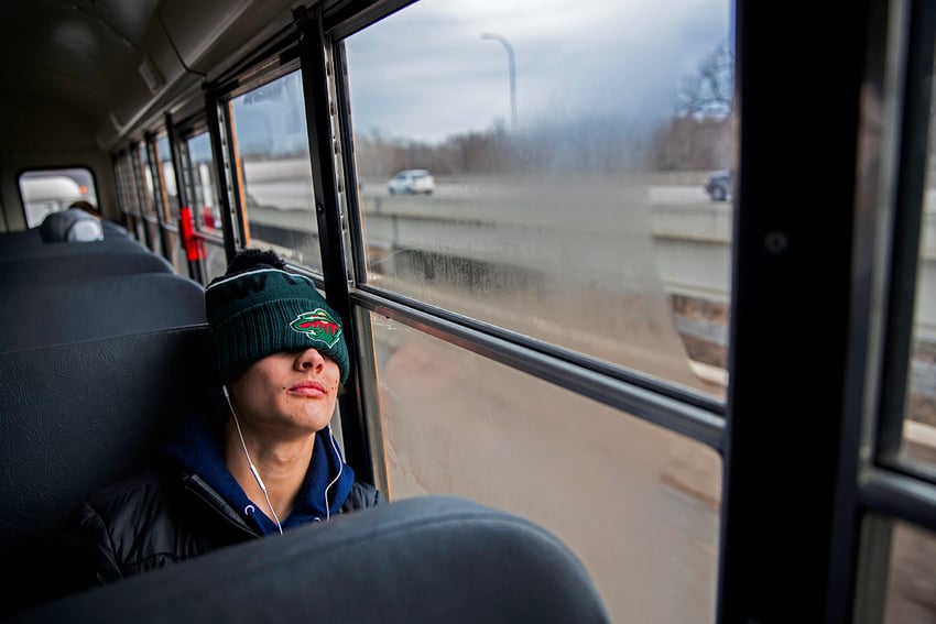 Photographer David Ellis' image of a high school ice hockey player napping on a school bus with white ear buds in his ears and a beanie with a pom-pom pulled over his eyes.