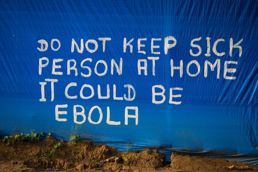 A fabric wall serves as a canvas for graffiti warning passersby of the potential dangers of Ebola. Photo by Christopher Beauchamp.
