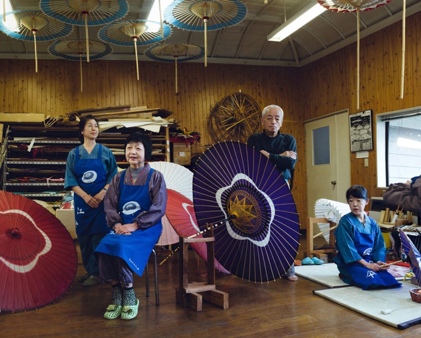 A quaint Wagasa craft shop, surrounded by four people immersed in the charm of traditional Japanese umbrellas (Wagasas), photo by Irwin Wong.