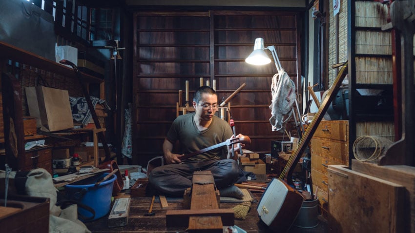 A dedicated artisan at work in his craft shop, skillfully creating with passion and precision, photo by Irwin Wong.