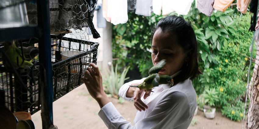 Photo of a woman holding a bird published on The Intercept taken as part of an IWMF Adelante reporting fellowship by Alicia Vera.