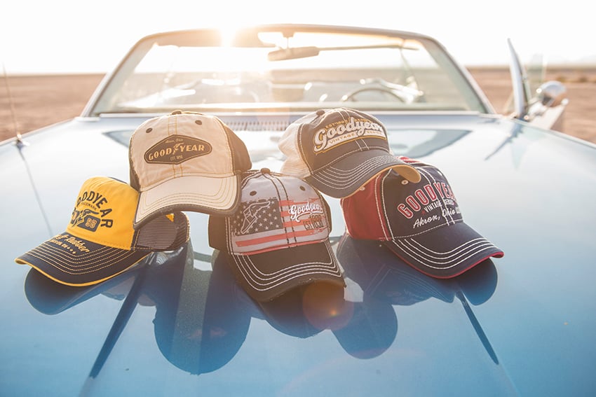 Photographer Jacob Kepler's photo for Goodyear Tire & Rubber Company.  The photo features 5 different styles of Goodyear brand baseball caps arranged on the hood of a blue convertible.