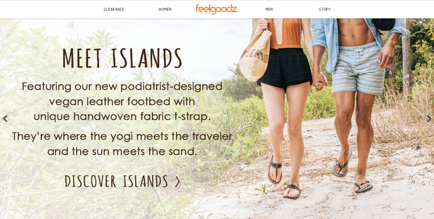 A screenshot of the FeelGoodz website featuring a photo by Jillian Clark. The photo shows the lower bodies of a couple in bathing suits and beachwear walking and holding hands. The focus is on their shoes.
