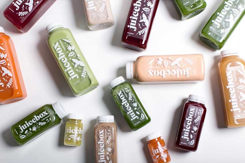 Brooke Fitts' photo for Juicebox featuring a flat lay of their bottled juices on a white background, taken from above.
