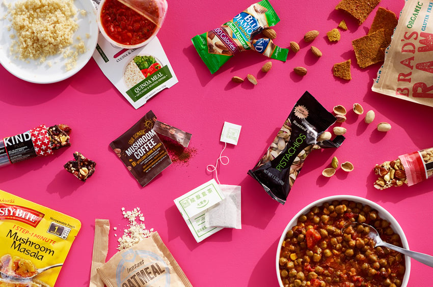 Kyle Dreier's photograph for Lifebox of a flat lay of packaged snacks and prepared dishes on a hot pink surface.