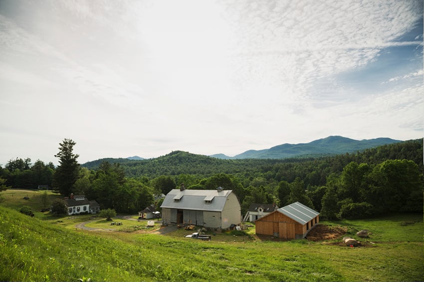 Lisa Godfrey's photo for Adirondack Life Magazine. The photo, taken from a hill above, features a small farm pressed up against a dense green forest.