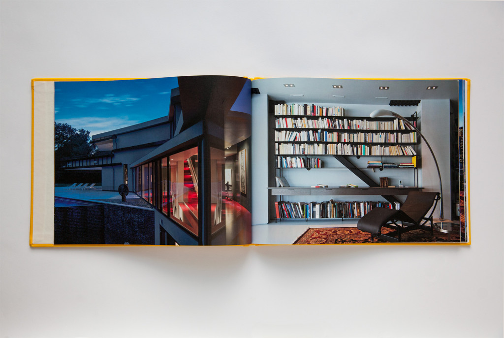 A print book open to a page showing the architecture photography of a home (left) and the interior of a home library (right)