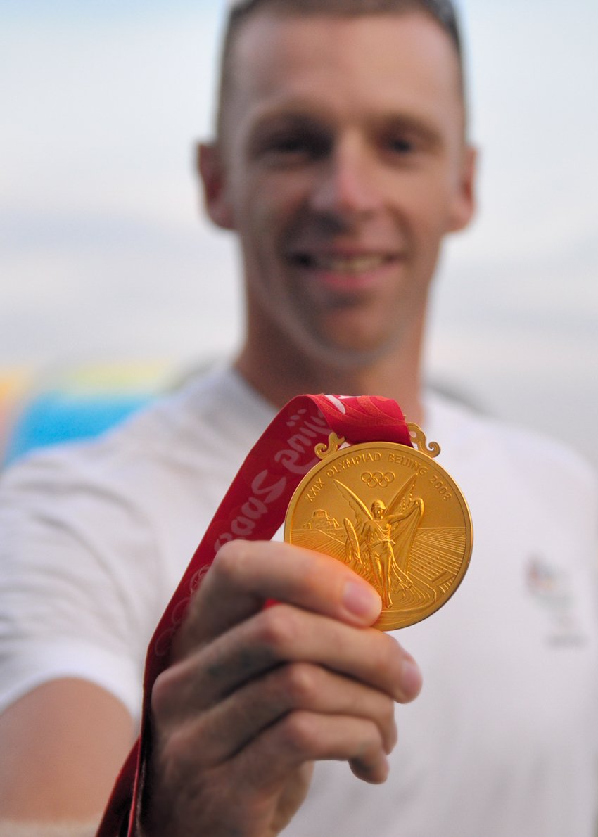 An athlete holding his gold Olympic medal in Beijing 2008 shot by Richard Wearne.