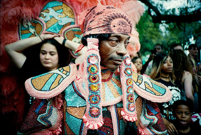 Vibrant Mardi Gras parade in New Orleans, featuring marchers adorned in captivating Indian attire, photo by Webb Chappell.