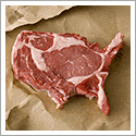 Food photography showing an uncooked steak in the shape of the united states