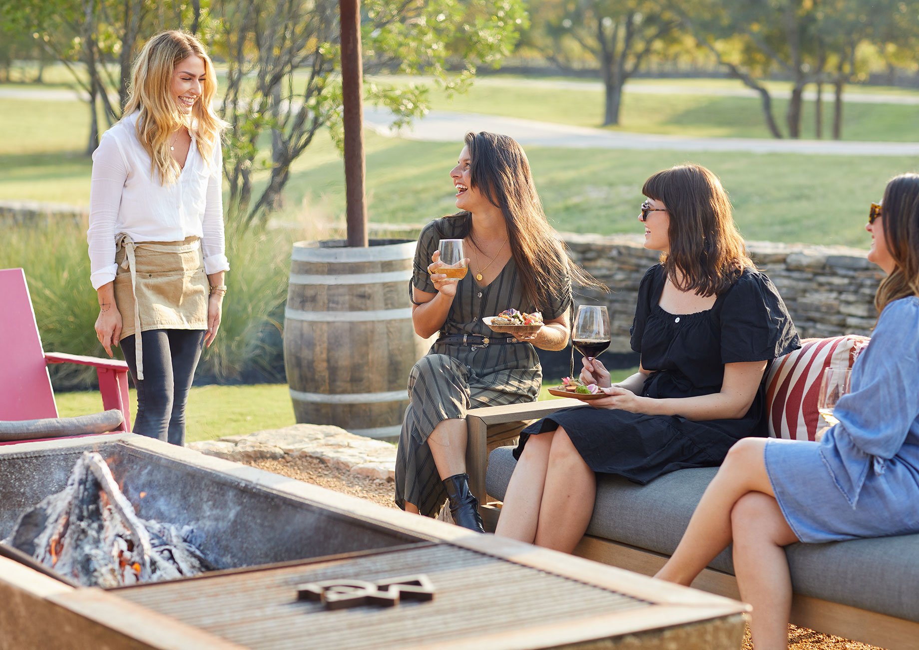 Friends laugh over drinks while being waited on at Driftwood Ranch shot by Buff Strickland