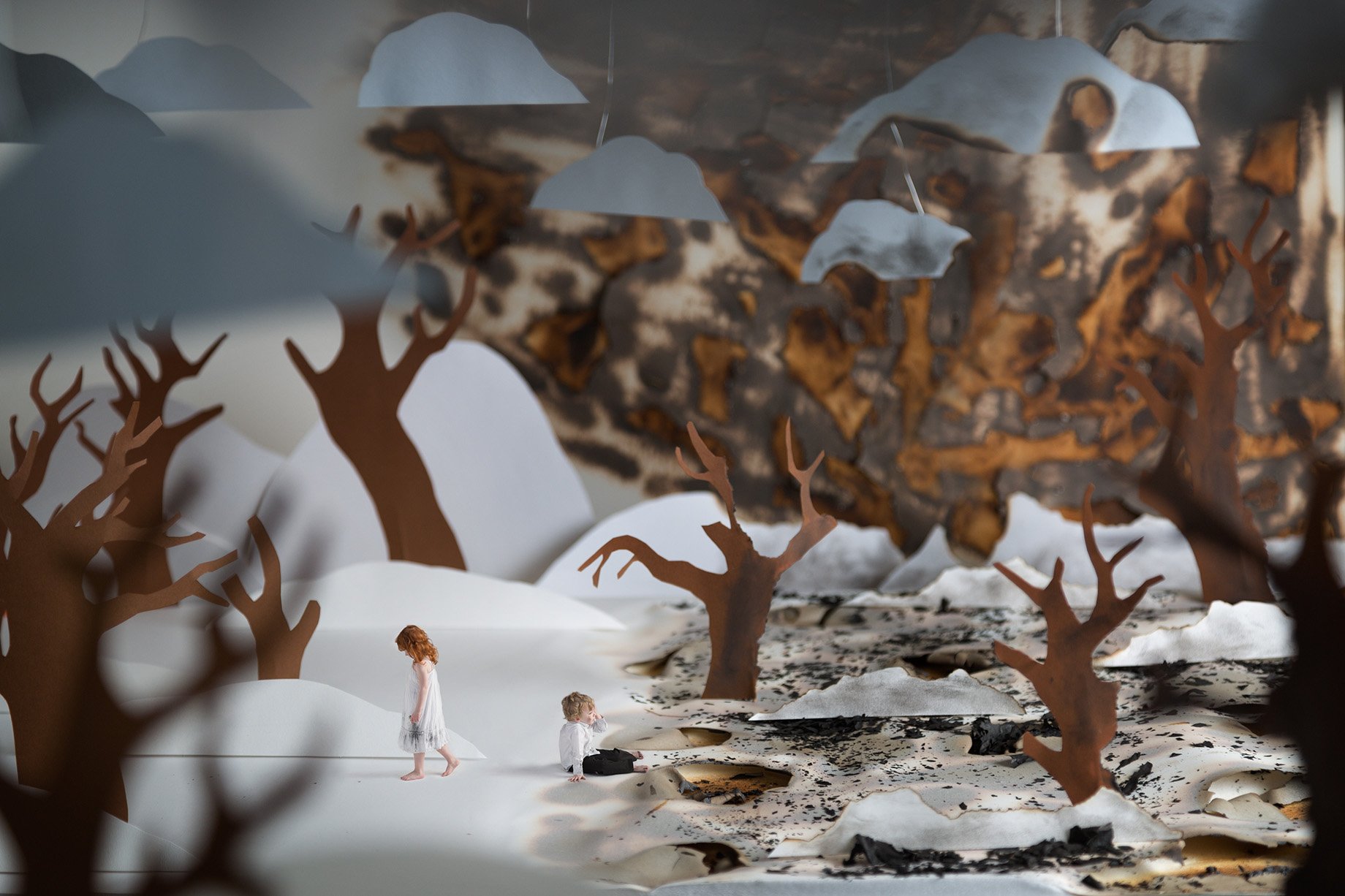 Two children roam a snowy and smoky plain made from construction paper shot by Patrick Heageny for Paper Thin