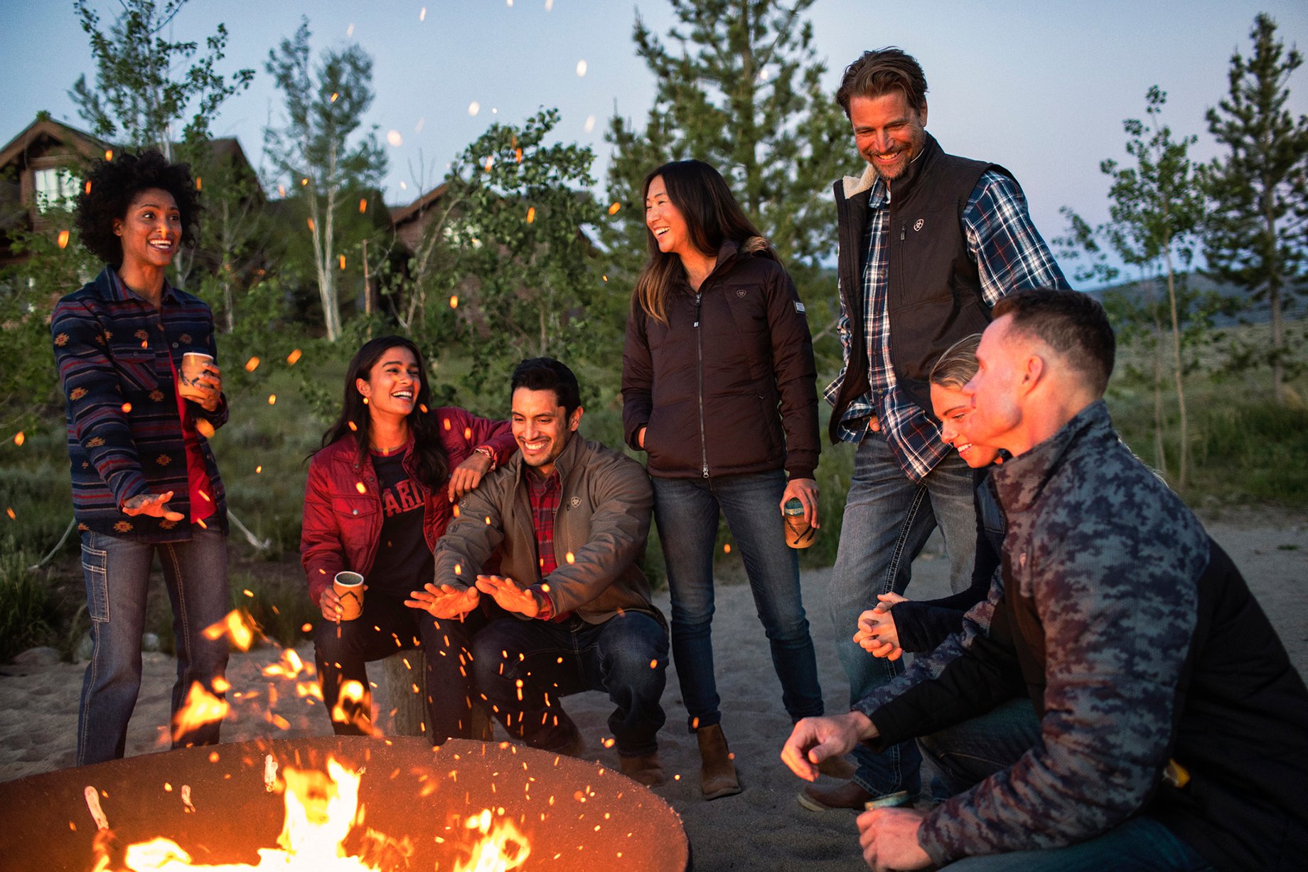 Friends around a campfire shot by Hillary Maybery for Ariat