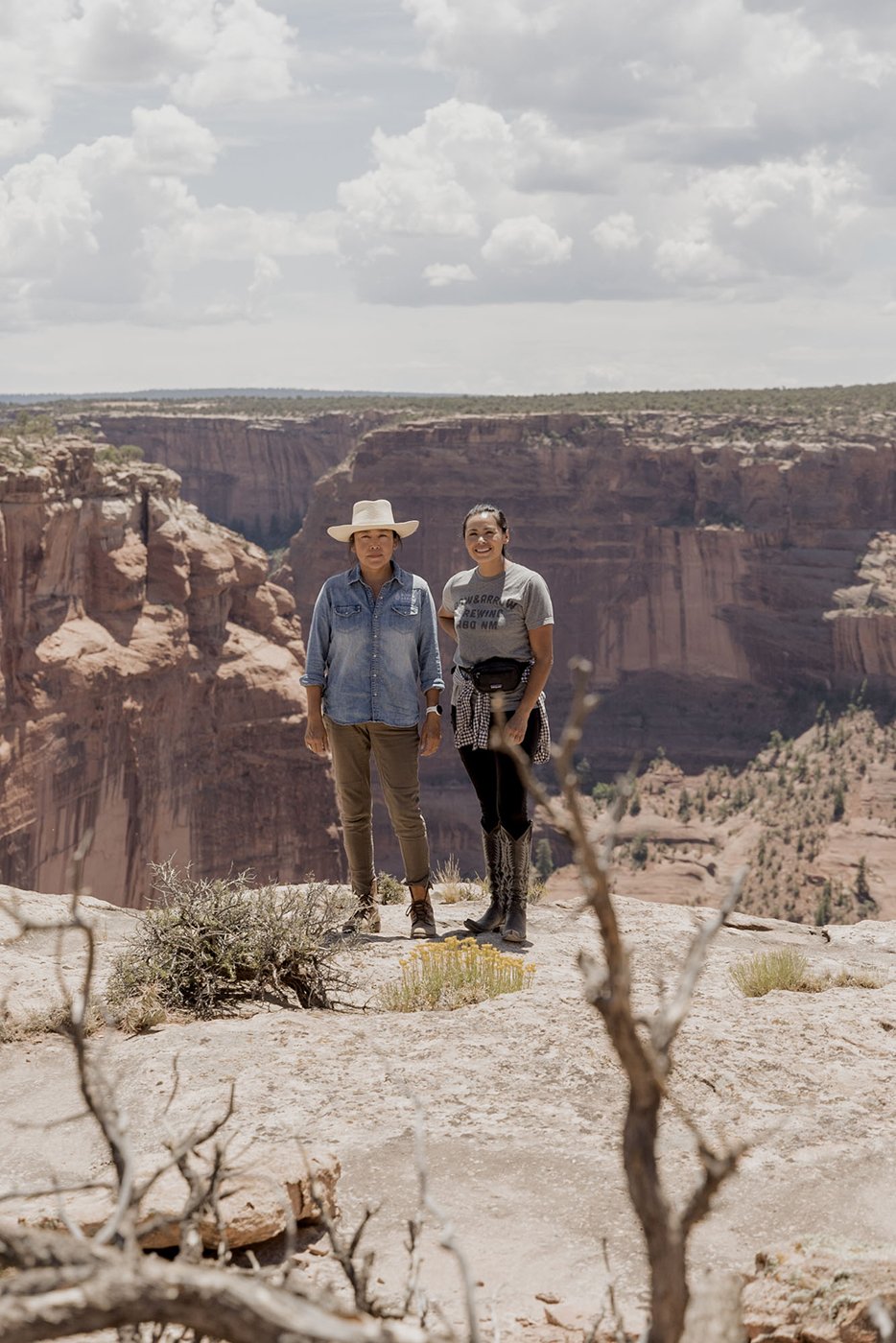 Missy Begay and Shyla Sheppard standing on the rim of Canyon de Chelly shot by Minesh Bacarina for Outside Magazine