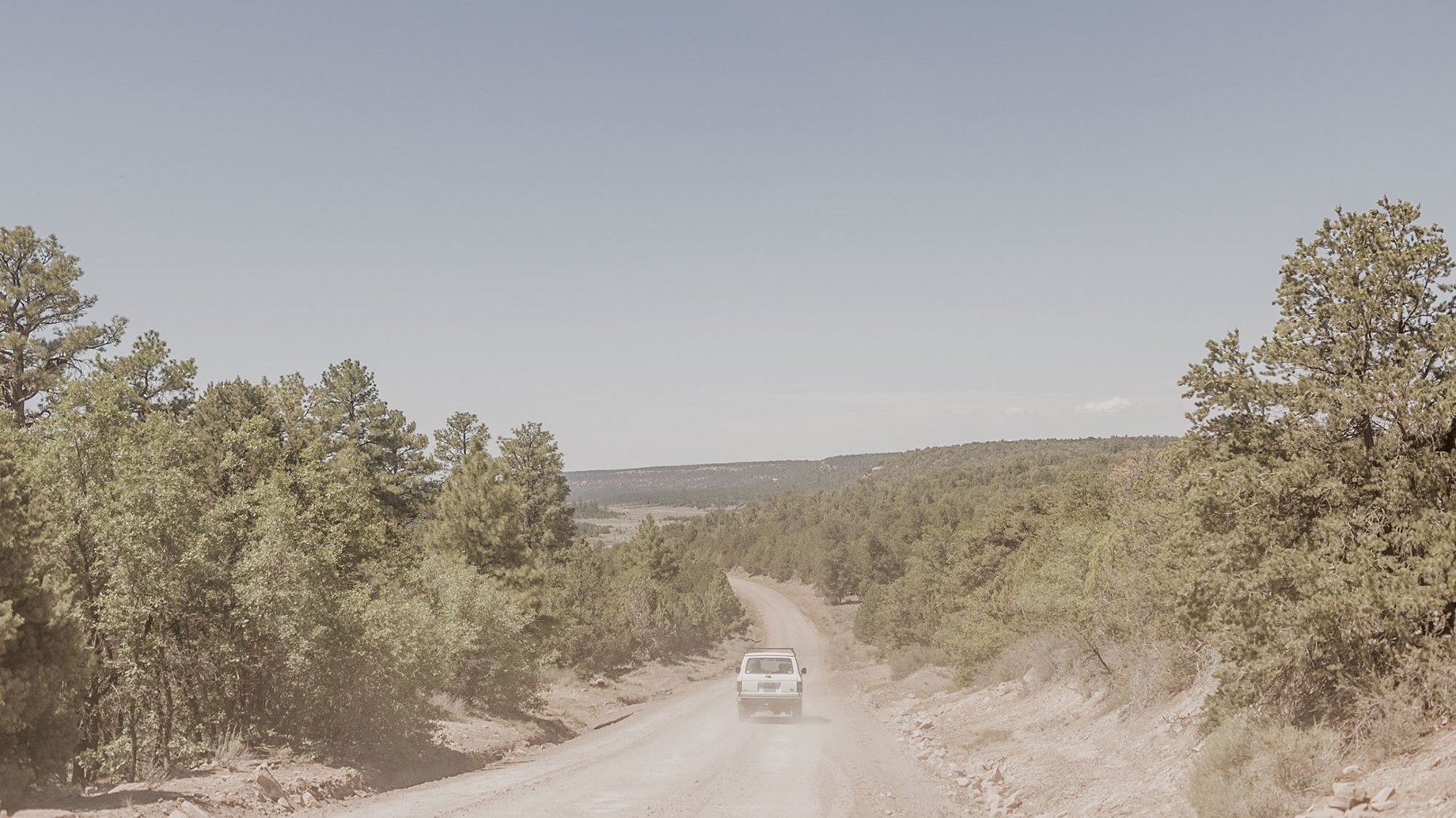 Car driving down a dirt road in New Mexico shot by Minesh Bacarina for Outside Magazine
