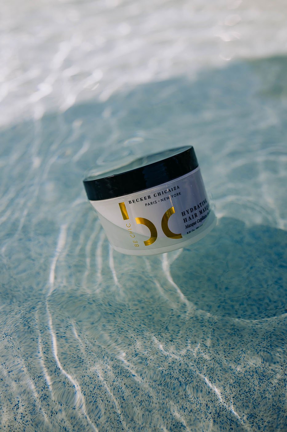 Be Chic Hydrating hair masque shot in a clear pool by Chad Savage