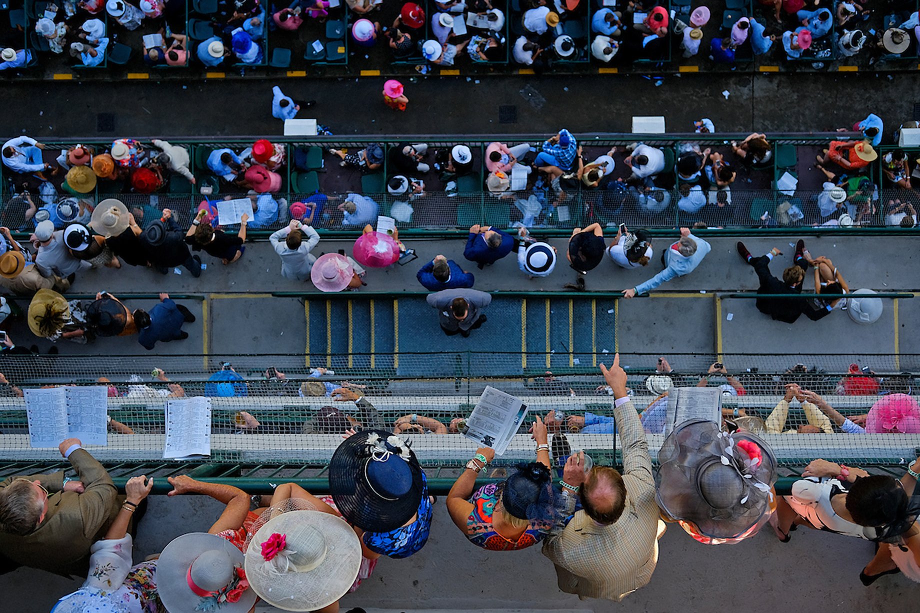 People look out on the balcony before the start of the Kentucky Derby shot by William DeShazer