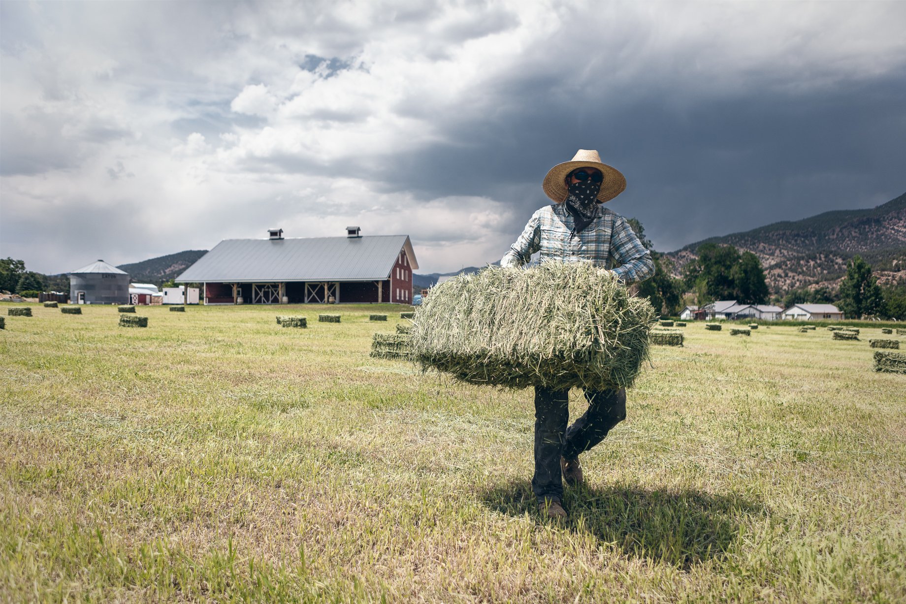 Farmer carrying bale of hay on Howard Creek Farm shot by Doug Gritzmacher