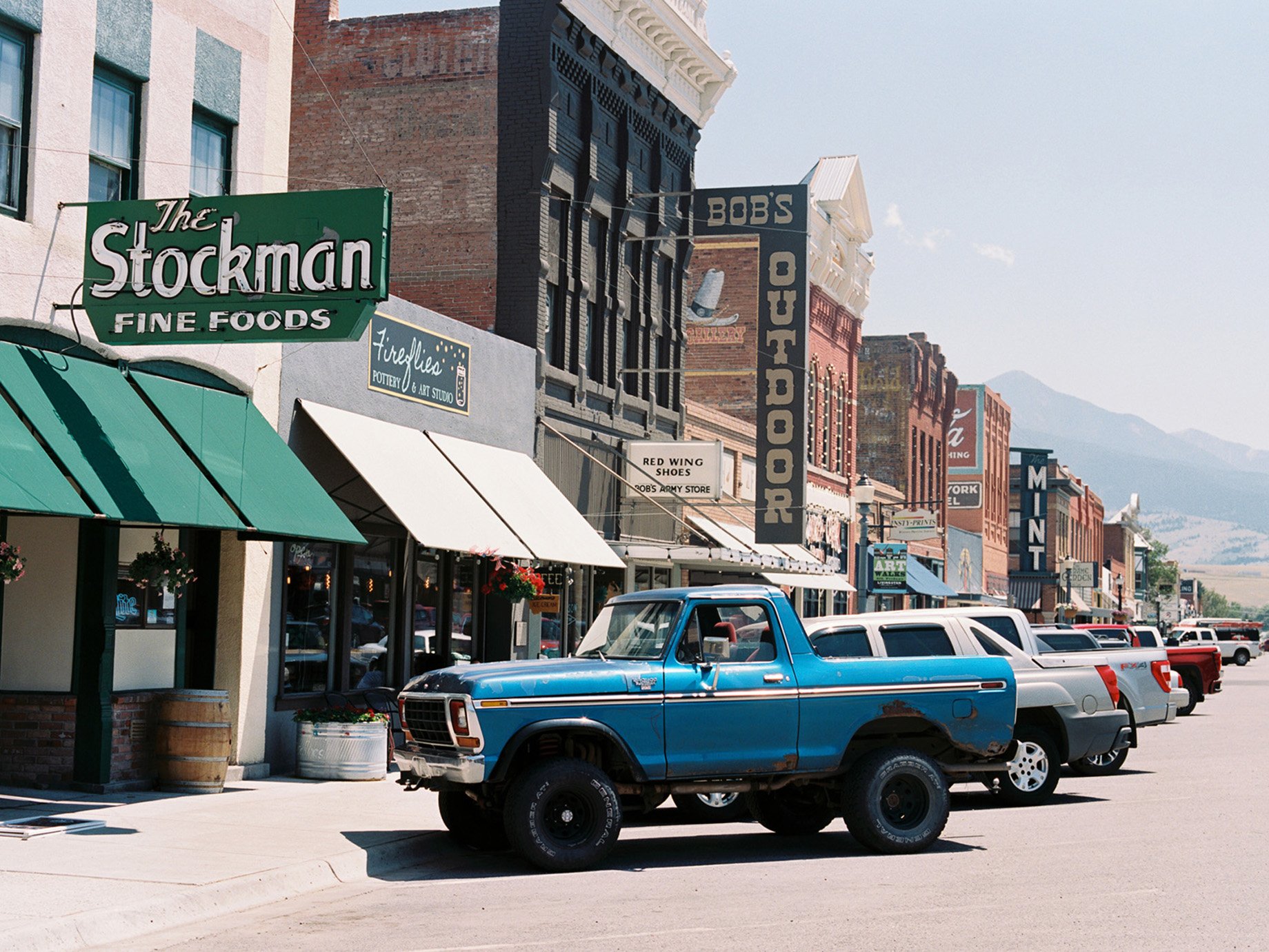 Old car in front of classic western shops in a mountain town in Montana shot by Abigail Bobo for First Opportunity Bank