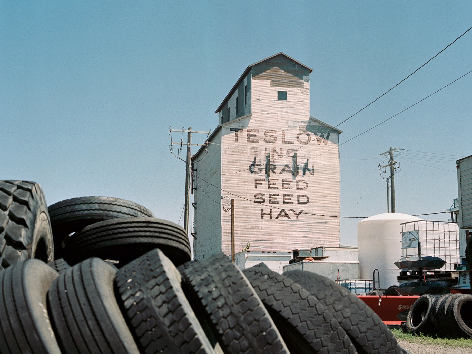 Tires stacked in front of silo tower on a farm in mountain town in Montana shot by Abigail Bobo for First Opportunity Bank