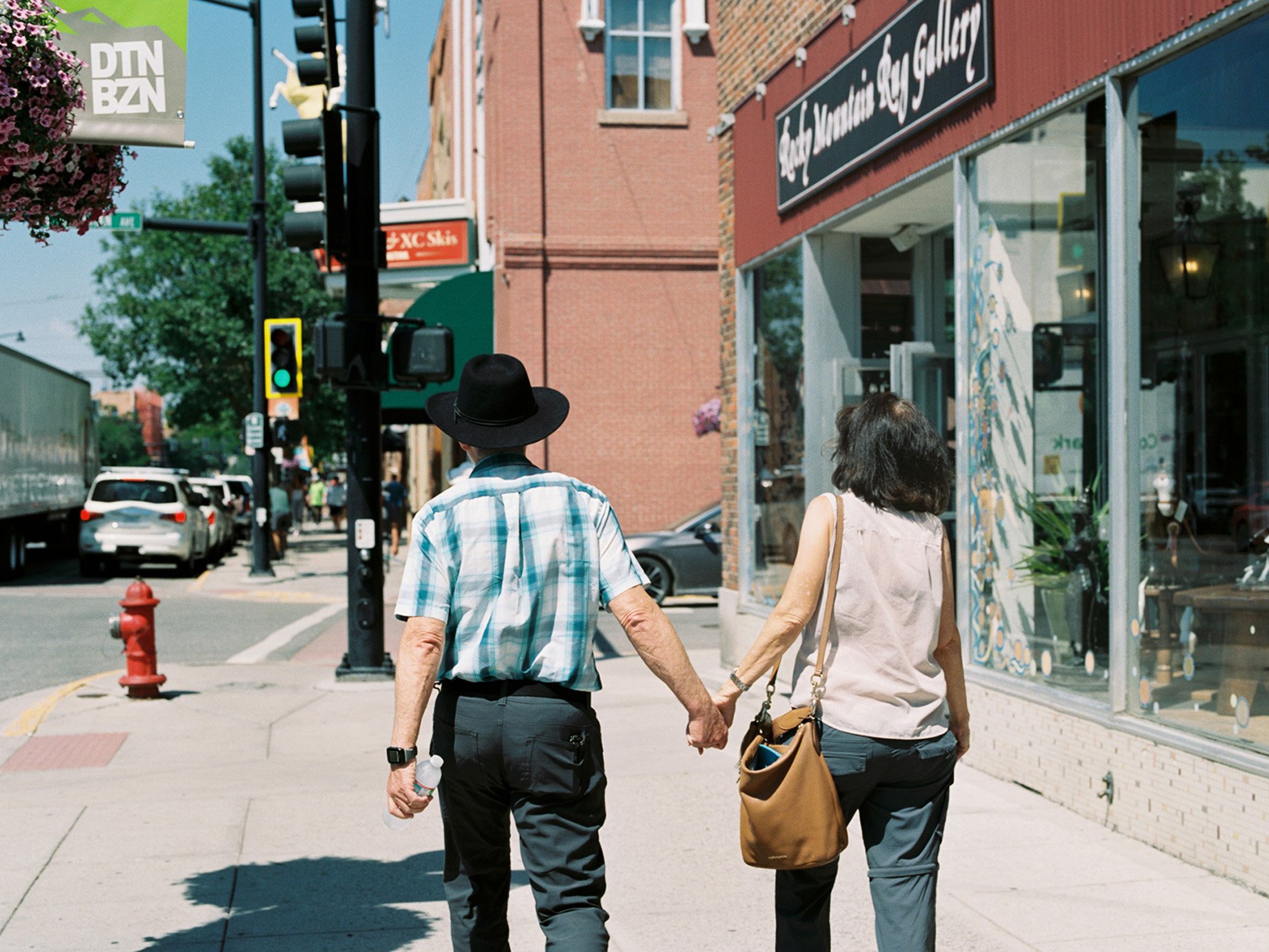 Montana couple holding hands as they walk down the main street shot by Abigail Bobo for First Opportunity Bank