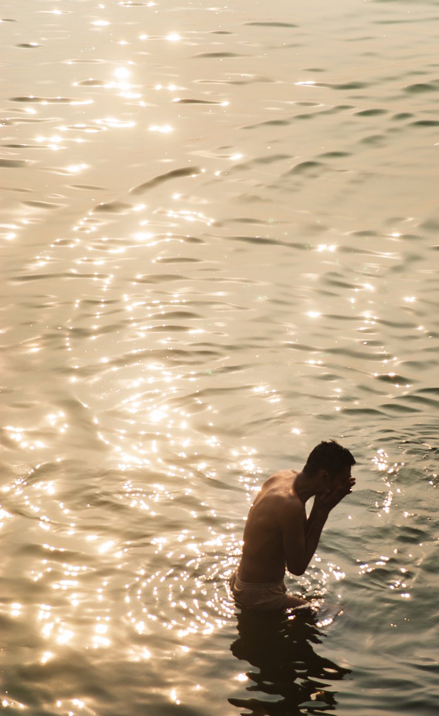 Man bathing in healing waters of Ganges in Varanasi shot by Michael Marquand for Lodestars Anthology.