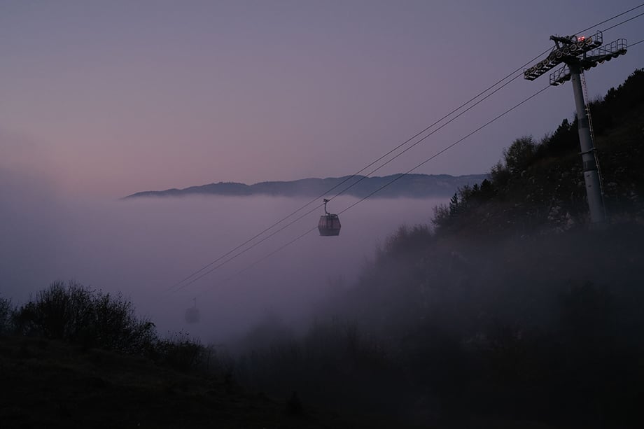 Cable cars rise out of a layer of fog and pollution on Mt. Trebevic, above Sarajevo. During periods of heavy pollution, the price of a return ticket is halved to encourage residents to spend time in the fresh mountain air. Photography by Nick St. Oegger. 