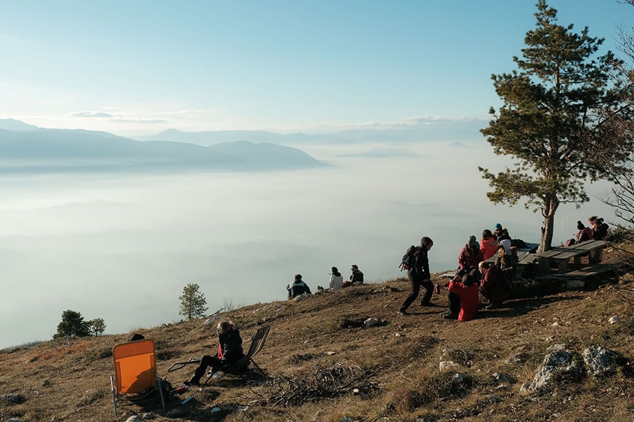 People picnic and take in the views near a mountain hut on Mt. Trebević as a layer of smog blankets Sarajevo below. The mountain often becomes incredibly crowded on weekends, with visitors spending time in the sun and fresh air of the mountain.Photography by Nick St. Oegger. 