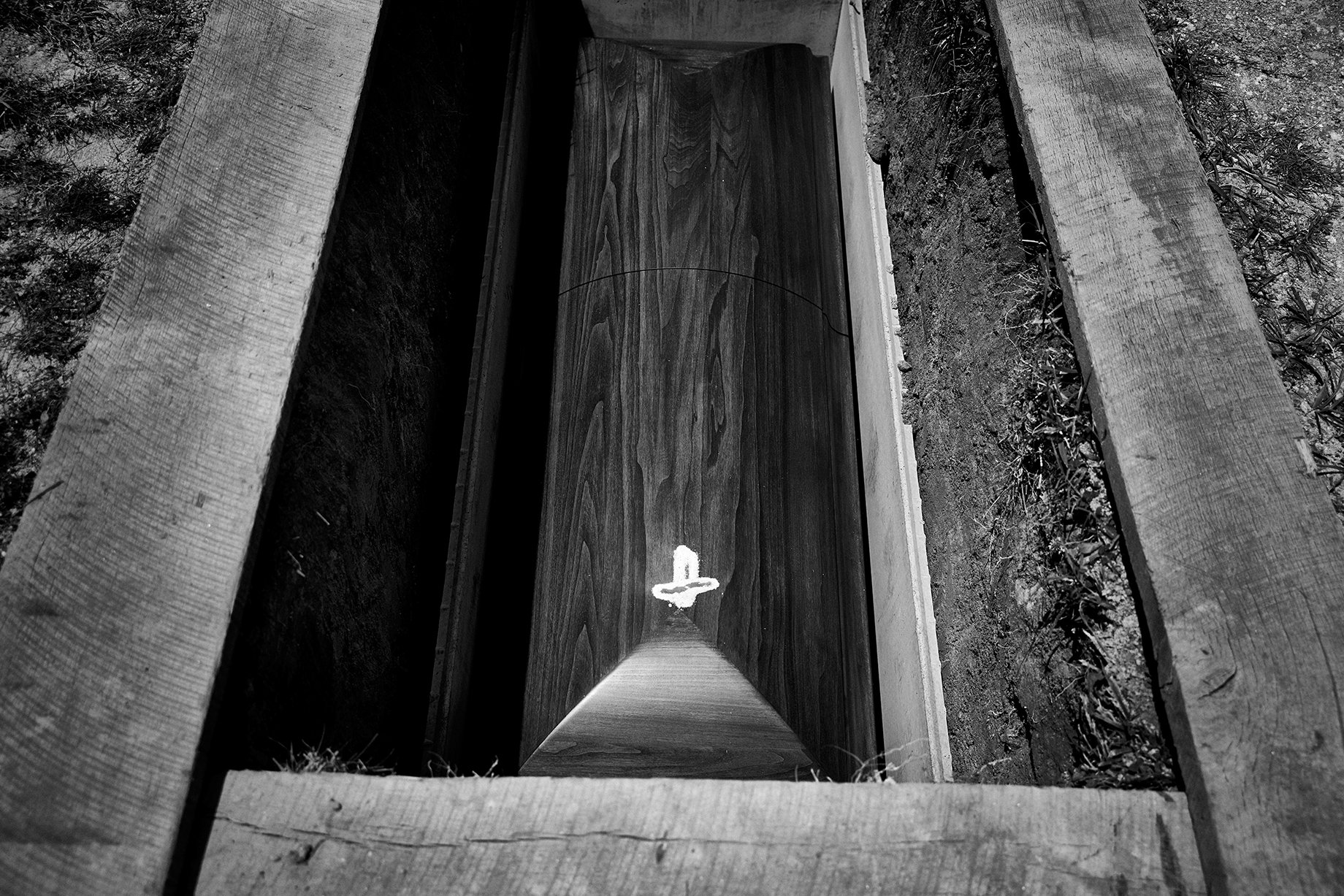 Photographer Sean Scheidt's grandfather's casket in the ground in black and white