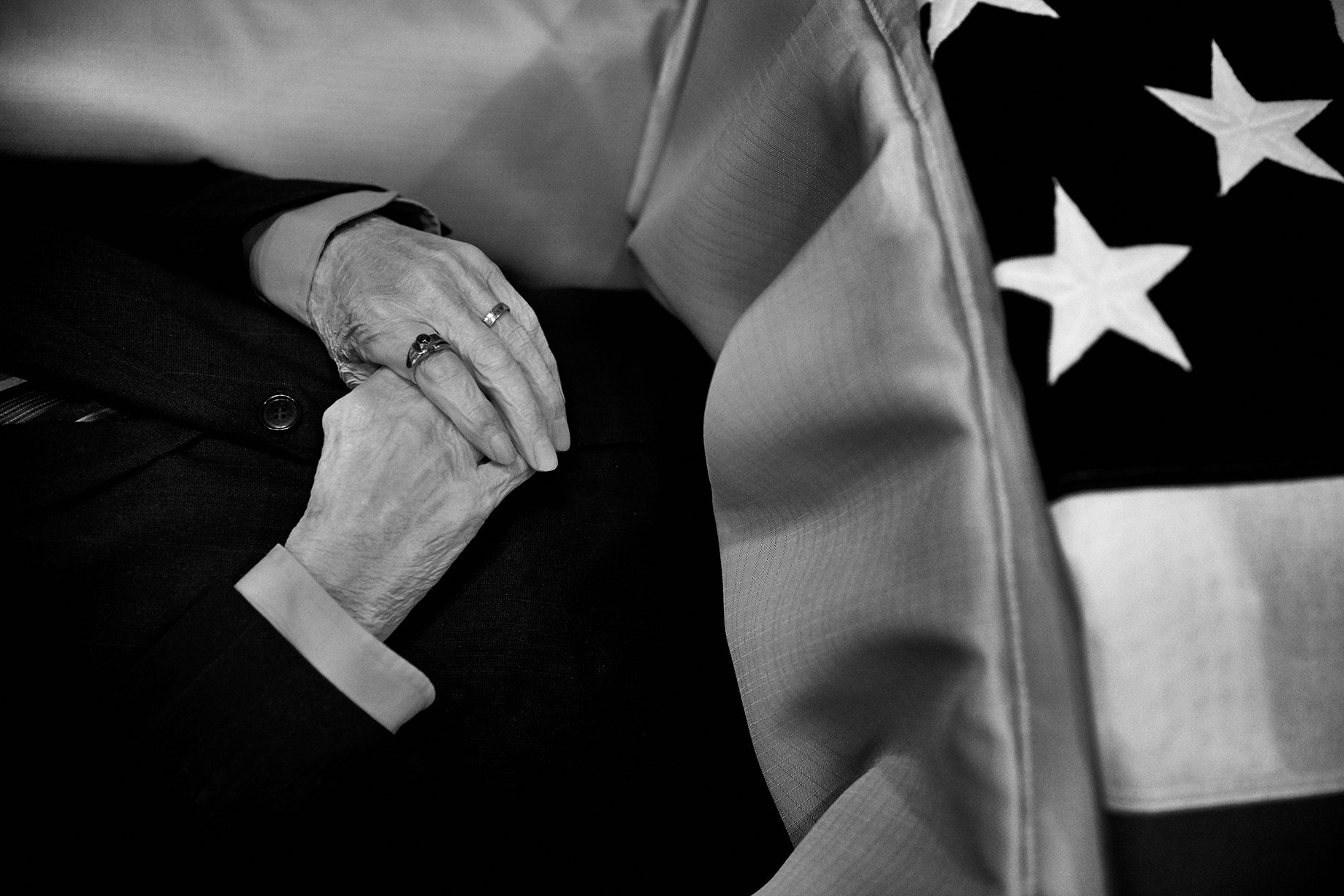 Photographer Sean Scheidt's grandfather's hands in his casket in black and white