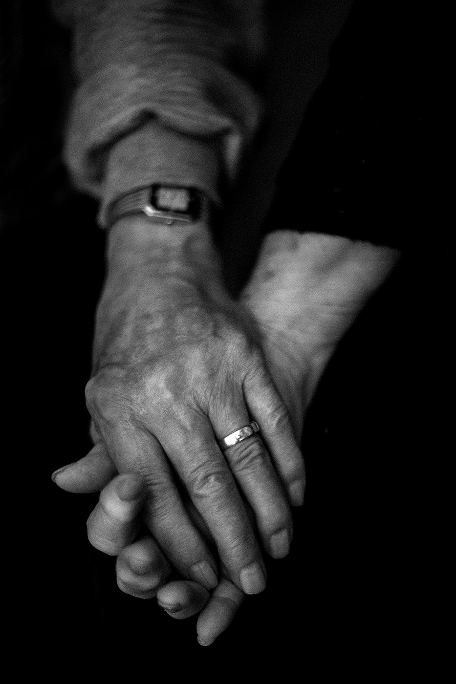 Photographer Sean Scheidt's grandparent's holding hands in black and white