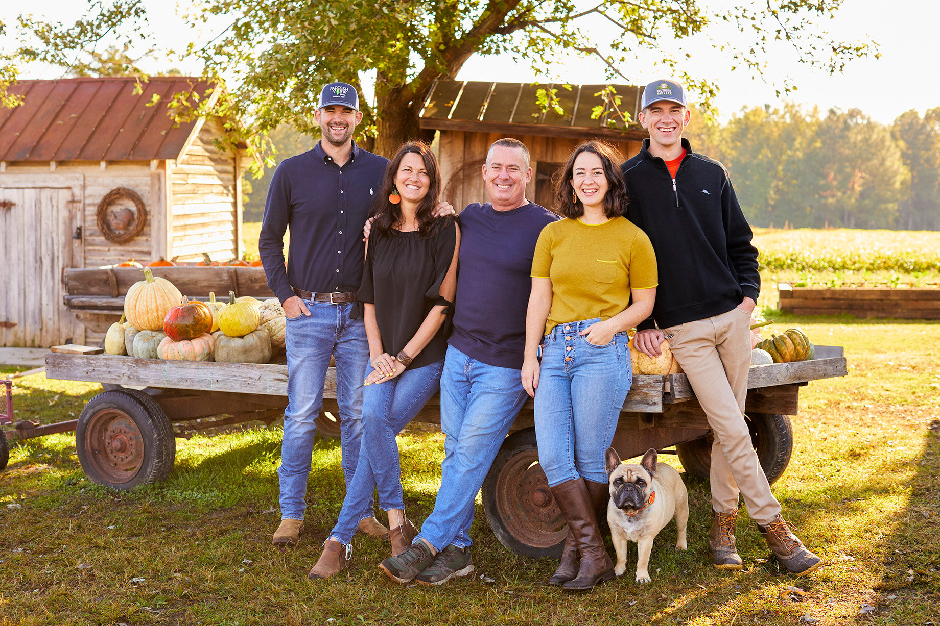 Parrish family and dog sitting in front of a wagon full of Pumpkins shot by Tyler Darden for Virginia Living magazine