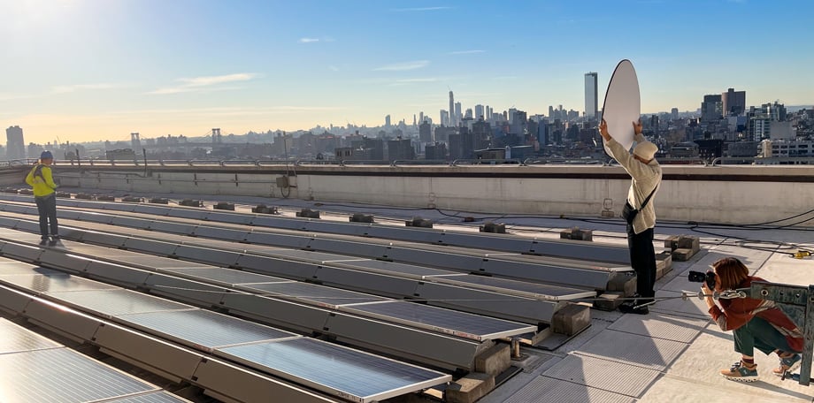 Photographer Emily Andrews and crew at Con Edison's solar paneled rooftop with the sprawling NYC skyline in the background. 
