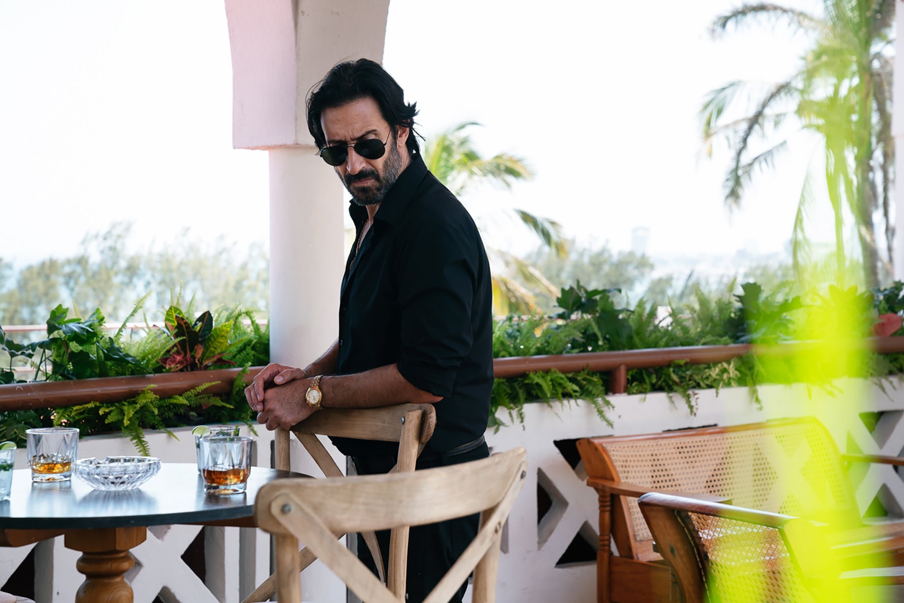 Man stands in tropical cantina in Narcos: Mexico season 3 shot by Nicole Franco for Netfllix