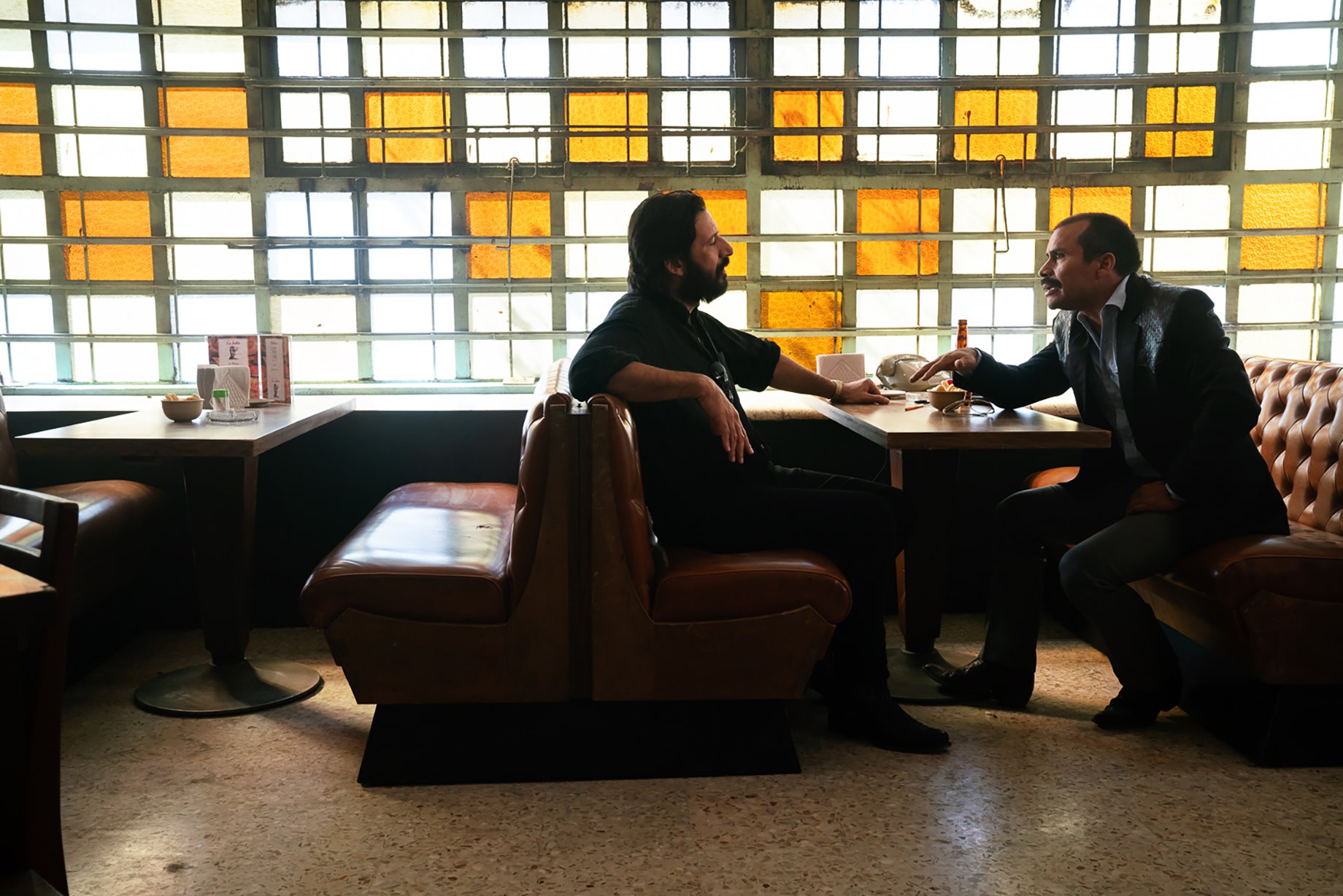 Two men talking at a restaurant for Narcos: Mexico season 3 shot by Nicole Franco for Netflix