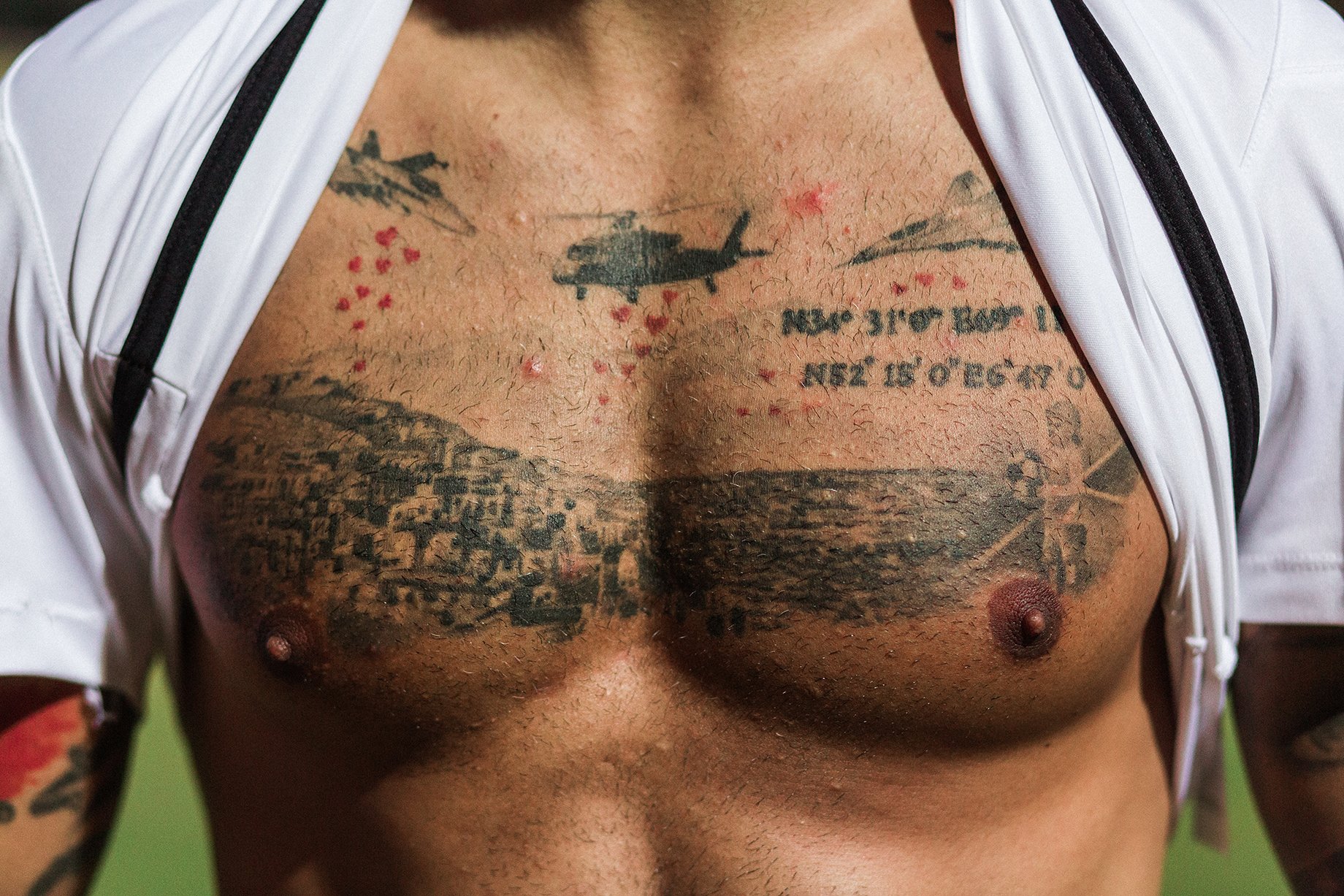 Faysal Sheyesteh of the Afghanistan National Soccer team, shows some of his tattoos, which all have a personal significance. On his chest he has a scene where war planes drop hearts onto Afghanistan, with the coordinates of a location near Kabul, and one in the Netherlands, where he grew up. Shot by Bradley Secker for the New York Times.