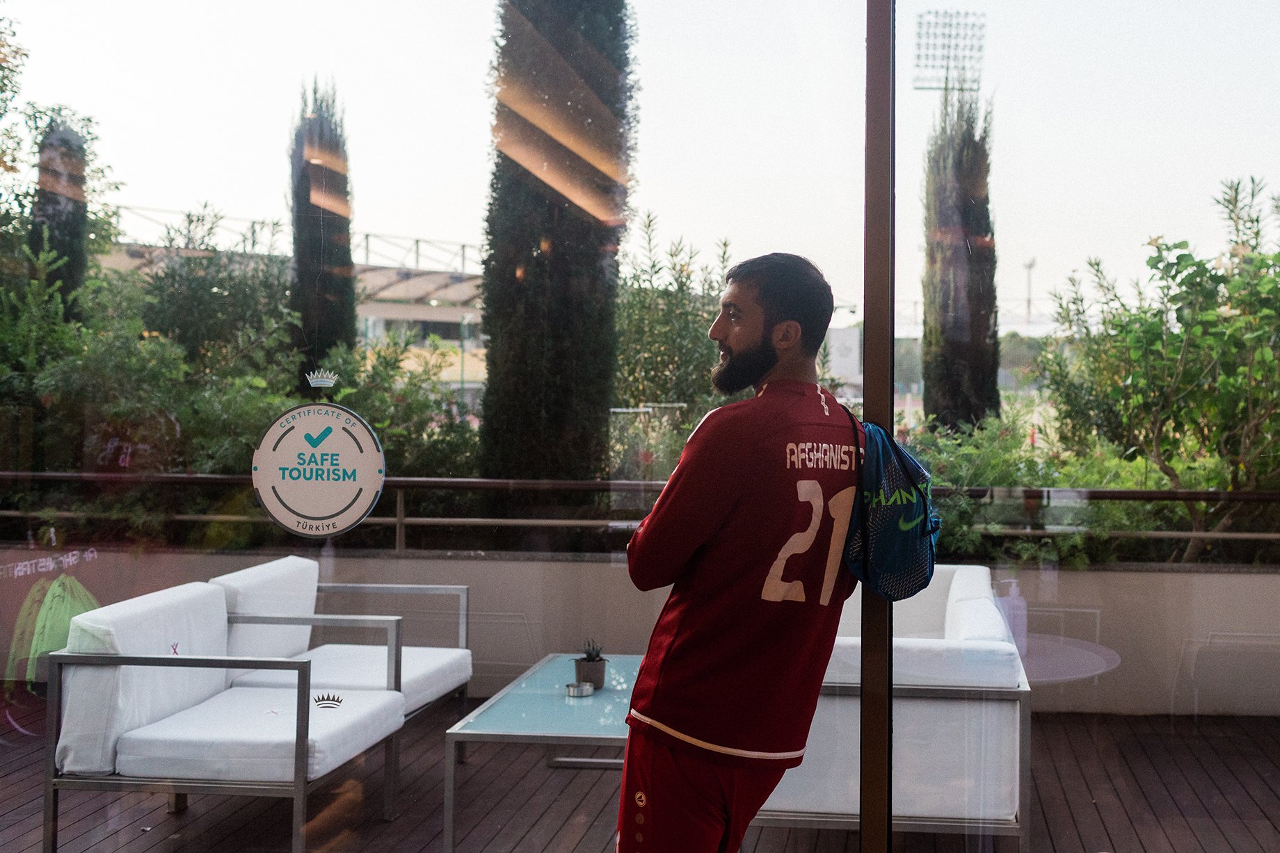 Sharif Mukhammad, a player on the Afghan national soccer team, stands in a hotel near the pitch before a training session. Shot by Bradley Secker for the New York Times.